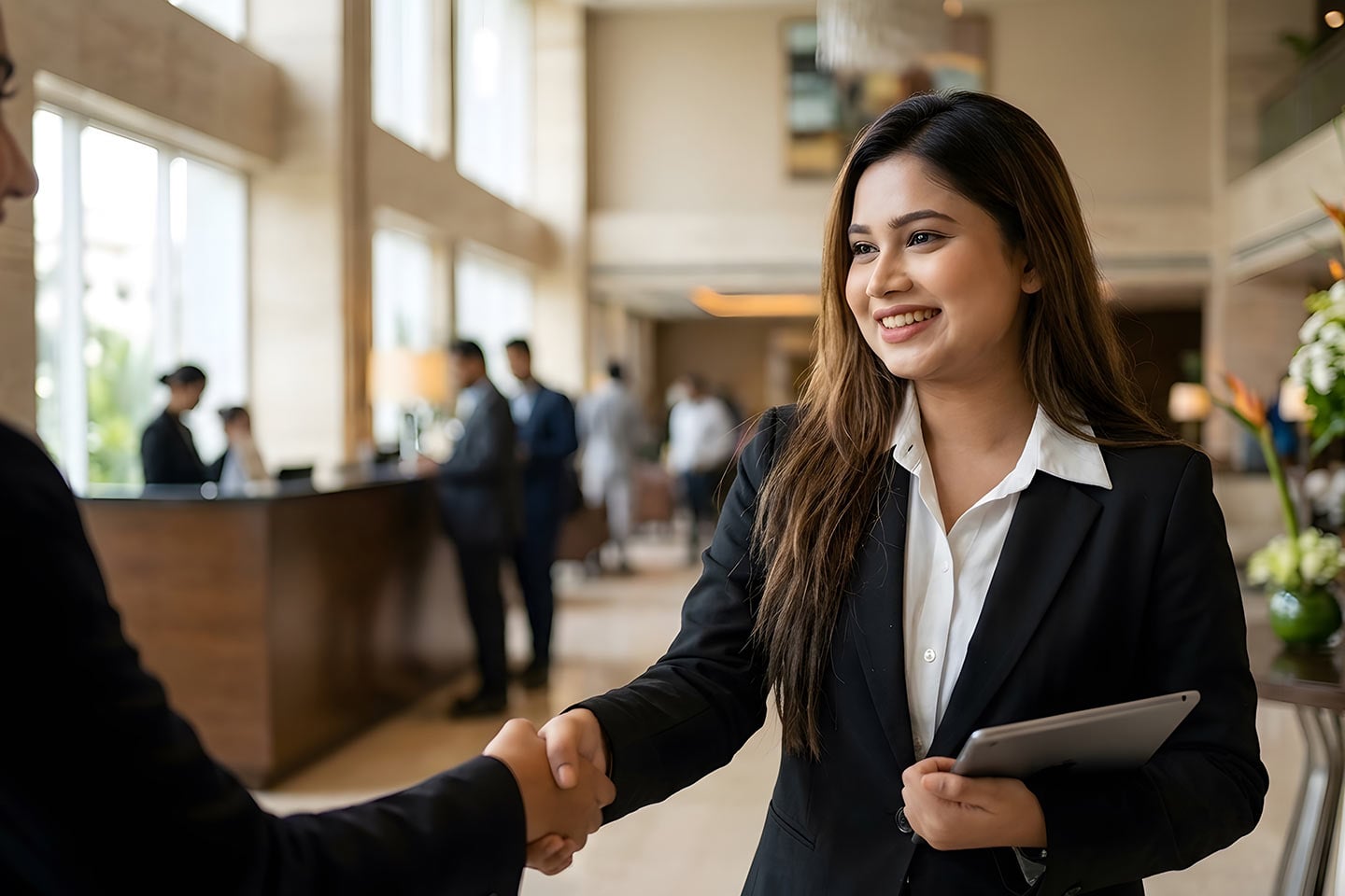 woman shaking hand in hotel lobby
